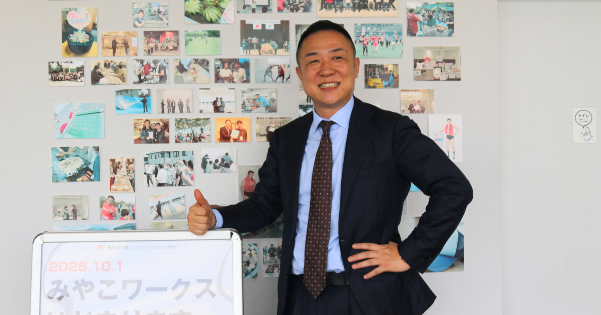 安本社長がガッツポーズしている写真